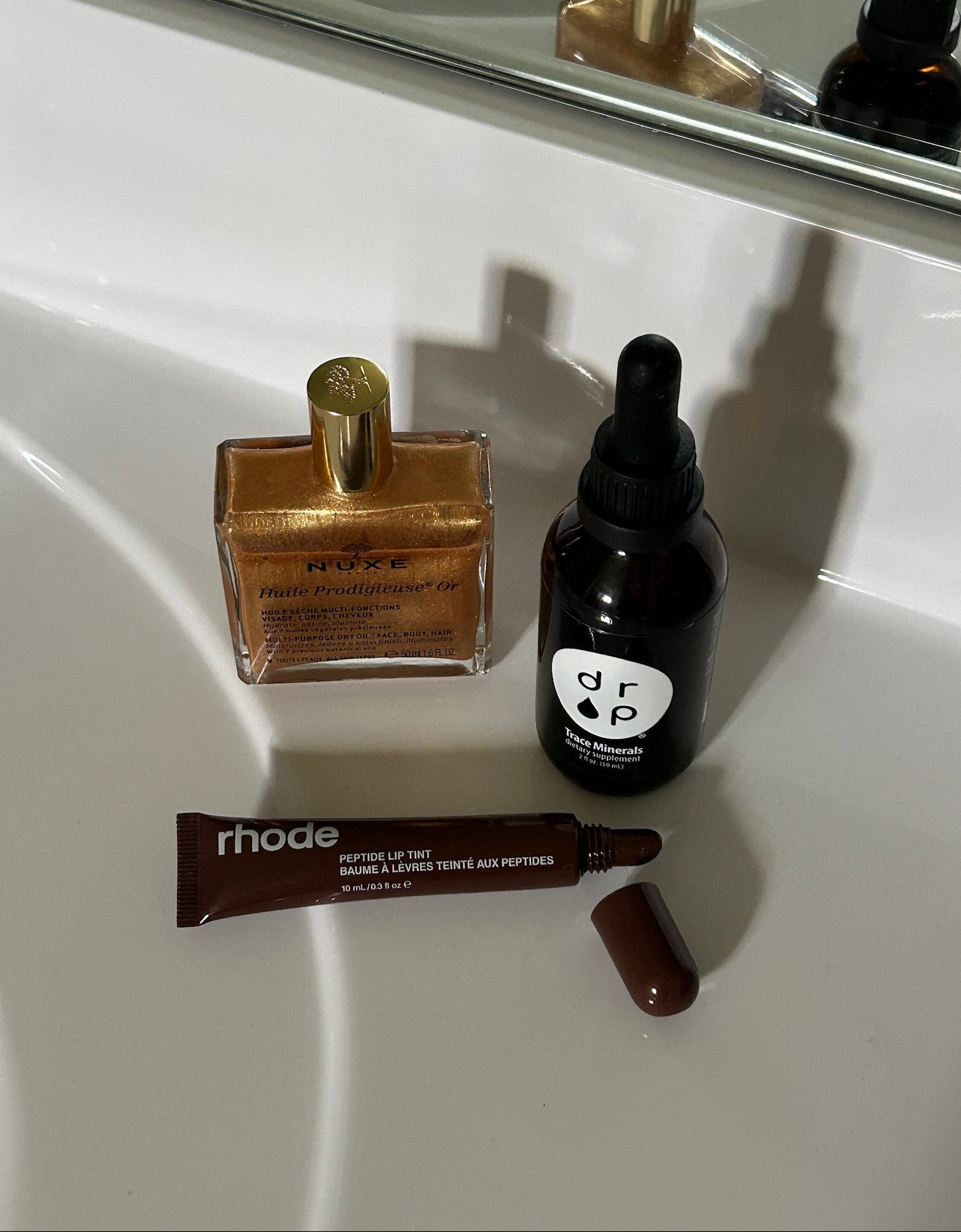 Cosmetic products including a bottle, a dropper, and a tube on a white surface.